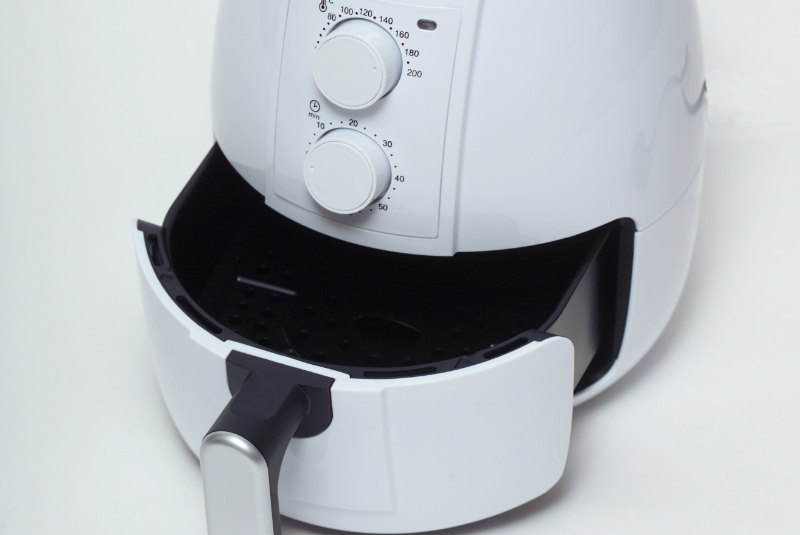 Imagem frontal de fritadeira a ar com a tampa semiaberta 